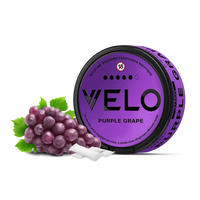 Ένα στρογγυλό, μοβ κουτάκι VELO Purple Grape βρίσκεται δίπλα σε ένα τσαμπί σταφύλια με πράσινα φύλλα. Μπροστά υπάρχουν δύο λευκά σακουλάκια νικοτίνης που είναι κατασκευασμένα από φυτικά συστατικά.