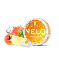 Ένα στρογγυλό κουτί VELO Tropical Ice βρίσκεται δίπλα σε φέτες ανανά, ροδάκινου και καρύδας, με δύο λευκά σακουλάκια νικοτίνης μπροστά. Το πορτοκαλί και λευκό κουτί διαθέτει έντονο κείμενο και σχέδιο εμπνευσμένο από γεύσεις τροπικών φρούτων.